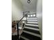 Modern staircase with sleek black railings and contrasting treads, leading to the upper level at 22223 Seyburn Ter, Port Charlotte, FL 33954