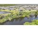 A beautiful view of a home's backyard bordering a lake with lush landscaping at 2232 Bonito Way, Port Charlotte, FL 33953