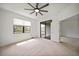 Bright bedroom with neutral carpet, a ceiling fan, and a sliding door to the outside at 2232 Bonito Way, Port Charlotte, FL 33953