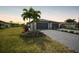 Charming home exterior with lush green landscaping, paver driveway, and two-car garage at 2232 Bonito Way, Port Charlotte, FL 33953