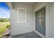 Close-up of the front door of the home, showcasing the light gray paint and adjacent wall fixture at 2232 Bonito Way, Port Charlotte, FL 33953