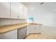 Bright kitchen with granite countertops, stainless steel dishwasher, and white cabinets at 2232 Bonito Way, Port Charlotte, FL 33953