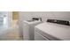 Well-equipped laundry room with modern washer and dryer units near the bathroom at 2232 Bonito Way, Port Charlotte, FL 33953
