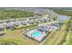 A high angle view of a community pool surrounded by homes, tennis courts, and a pond at 2232 Bonito Way, Port Charlotte, FL 33953