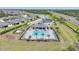 An aerial view of the community pool and surrounding palm trees, amenity center, and tennis courts at 2232 Bonito Way, Port Charlotte, FL 33953