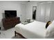 Comfortable bedroom boasts a dresser with television, bright white tile floor and closet with mirrored doors at 23442 Harper Ave, Punta Gorda, FL 33980