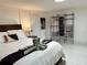 Bedroom with bed, open closet, and white tile floors at 23442 Harper Ave, Punta Gorda, FL 33980