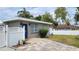 Charming single story home with a blue front door and colorful brick paver driveway at 23442 Harper Ave, Punta Gorda, FL 33980