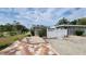 Charming home exterior with a colorful tiled driveway, manicured landscaping, and white picket fence at 23442 Harper Ave, Punta Gorda, FL 33980