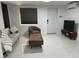Bright living room with gray sofa, cozy chair, modern coffee table, television and beautiful marbled tile flooring at 23442 Harper Ave, Punta Gorda, FL 33980
