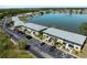 Aerial view of a two-story condo complex with ample parking overlooking a scenic lake and fountain at 25225 Rampart Blvd # 205, Punta Gorda, FL 33983