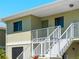 Exterior view of a two-story condo building with stairs leading to the upper-level unit at 25225 Rampart Blvd # 205, Punta Gorda, FL 33983