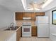 This kitchen boasts white appliances, tiled floor, fan, and lots of natural light at 25225 Rampart Blvd # 205, Punta Gorda, FL 33983