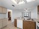 Open concept kitchen with stainless steel sink, tiled floor, and warm wood cabinetry at 25225 Rampart Blvd # 205, Punta Gorda, FL 33983