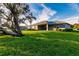 Expansive backyard with lush green lawn and shade trees create a serene outdoor oasis at 27260 Porto Nacional Dr, Punta Gorda, FL 33983