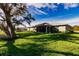 Spacious backyard includes a screened lanai, mature trees, and green lawn at 27260 Porto Nacional Dr, Punta Gorda, FL 33983