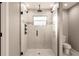 Modern bathroom shower featuring white tile, black hardware, and a glass enclosure at 27260 Porto Nacional Dr, Punta Gorda, FL 33983