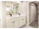 Bathroom with double sink vanity, large mirror, and shower with black fixtures at 27260 Porto Nacional Dr, Punta Gorda, FL 33983