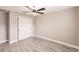 Neutral bedroom featuring modern ceiling fan, light gray walls, and wood-look flooring at 27260 Porto Nacional Dr, Punta Gorda, FL 33983