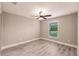 Bedroom with light gray walls, wood-look flooring, and a window with green view at 27260 Porto Nacional Dr, Punta Gorda, FL 33983