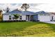 Beautiful single Gathering home showcasing a well-manicured lawn, lovely landscaping, and a two-car garage at 27260 Porto Nacional Dr, Punta Gorda, FL 33983