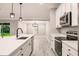 Bright kitchen with white cabinets, stainless steel appliances, an island with sink, and backyard views at 27260 Porto Nacional Dr, Punta Gorda, FL 33983