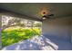 Covered lanai with ceiling fan overlooks the manicured backyard and landscaping at 27260 Porto Nacional Dr, Punta Gorda, FL 33983