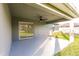A covered patio with fan overlooks a beautifully landscaped backyard at 27260 Porto Nacional Dr, Punta Gorda, FL 33983