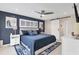 Stylish bedroom featuring a dark blue accent wall, plantation shutters, and barn door, combining modern design and comfort at 280 Belvedere Ct, Punta Gorda, FL 33950