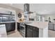 Modern kitchen with stainless oven, dark cabinets, quartz countertop, and ship wheel decoration at 280 Belvedere Ct, Punta Gorda, FL 33950
