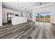 Open-concept living room with modern light fixtures and a view into the kitchen with stainless steel appliances at 3297 Swanee Rd, Punta Gorda, FL 33980