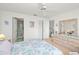 Cozy bedroom featuring floral bedding, ensuite bathroom, dresser and closet for storage at 3310 Loveland Blvd # 1906, Punta Gorda, FL 33980