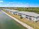 Exterior aerial view of lakeside condos with screened in lanais, rock seawall and lush landscaping at 3310 Loveland Blvd # 1906, Punta Gorda, FL 33980