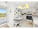 Well-lit kitchen with white cabinets, appliances, decorative fish, and a cozy breakfast table at 3310 Loveland Blvd # 1906, Punta Gorda, FL 33980