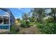 Spacious backyard with lush greenery and foliage, and a screened in porch and a seating area at 3357 Vassar St, Port Charlotte, FL 33980