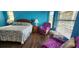 Spacious bedroom features wood floors, bright-blue walls, and a decorative bedspread at 3357 Vassar St, Port Charlotte, FL 33980