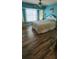 Bedroom with wood-look flooring, large window, fan, and bed with floral comforter at 3357 Vassar St, Port Charlotte, FL 33980