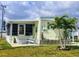 Charming home featuring a lovely patio with rocking chairs, tropical landscaping, and a delightful nautical theme at 354 Blackburn Blvd, North Port, FL 34287