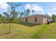Spacious backyard featuring a large lawn and wooded view at 401 Calendar St, Port Charlotte, FL 33954