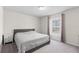 Bright bedroom with a cozy bed, soft carpet, and natural light streaming through the window at 401 Calendar St, Port Charlotte, FL 33954