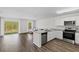 Open-concept kitchen with granite counters, stainless appliances and sliding door to yard at 401 Calendar St, Port Charlotte, FL 33954
