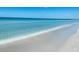 A beautiful view of waves crashing on a white sand beach underneath a clear blue sky at 4168 Harbor Blvd, Port Charlotte, FL 33952