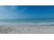 A beautiful view of waves lapping on a sandy beach with a clear blue sky at 4168 Harbor Blvd, Port Charlotte, FL 33952