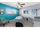 Bright room with massage table, bright blue accent wall, and ceiling fan at 4168 Harbor Blvd, Port Charlotte, FL 33952