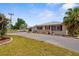 Charming single-story home with a well-maintained lawn and a stone-accented facade, complemented by mature palm trees at 4168 Harbor Blvd, Port Charlotte, FL 33952