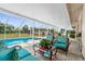 Inviting screened-in patio showcasing comfortable lounge furniture with decorative cushions, and the pool in the backyard at 4168 Harbor Blvd, Port Charlotte, FL 33952