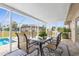 Screened-in patio featuring a dining table set and a patterned rug overlooking the pool and well-maintained backyard at 4168 Harbor Blvd, Port Charlotte, FL 33952