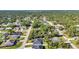 An aerial view reveals homes with green lawns and mature trees in a spread-out neighborhood at 4331 Marcella Ter, North Port, FL 34286