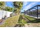 Grassy backyard with white fence and tropical landscaping at 4331 Marcella Ter, North Port, FL 34286
