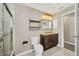 Bright bathroom featuring a glass door shower, wooden vanity with a dark countertop and decorative mirror at 4331 Marcella Ter, North Port, FL 34286